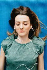 Picture of young person lying down listening to music